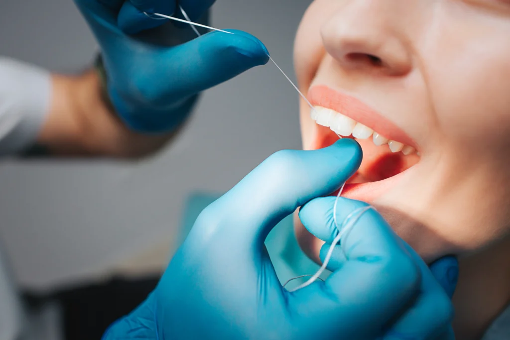 Soin dentaire réalisé avec un instrument, patiente souriante