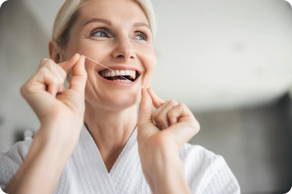 Femme souriante, mains sur les joues, satisfaite de son sourire